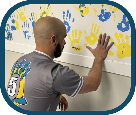 high 5 team member painting hand on wall