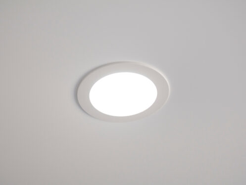 A round, recessed ceiling light is turned on, emitting bright white lighting. The IC rating ensures the fixture is safely installed in the smooth, plain white ceiling. | High 5 Plumbing, Heating & Cooling