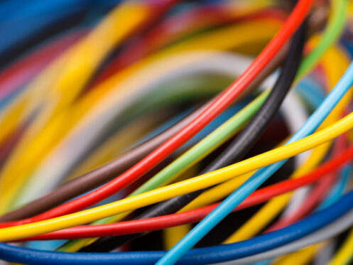 Close-up view of a tangled bundle of colorful electrical wires, including red, yellow, blue, black, and white, demonstrating various thicknesses and textures useful for wire identification and understanding electrical wire color codes. | High 5 Plumbing, Heating & Cooling